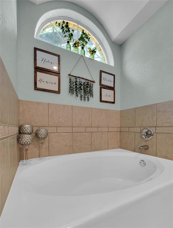 37 Bluebonnet Loop Morgan's Point Resort, TX 76513 - Photo 20 of 38 Corner soaking tub with chrome fixtures, surrounded by light-toned tile wainscoting