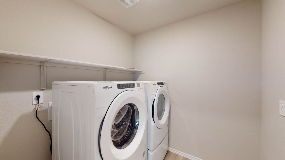575 Hector Loop Georgetown, TX 78626 - Photo 27 of 28 Dedicated utility area featuring a front-loading washer and dryer set, built-in shelving, wall outlet, and light-toned flooring