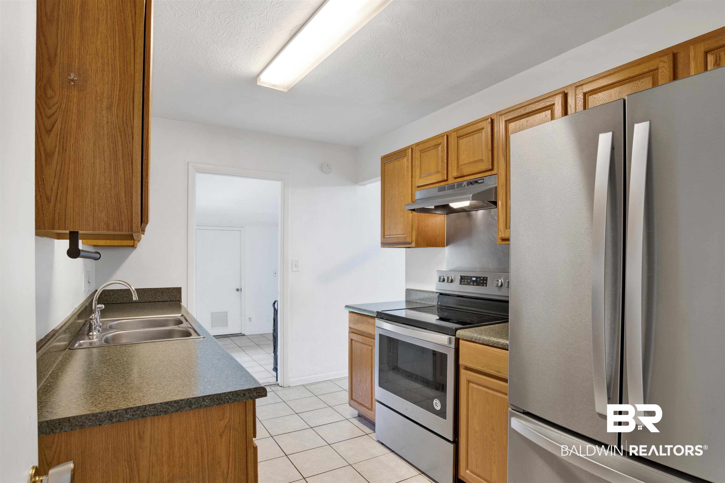 2 Lee Circle Daphne, AL 36527 - Photo 3 of 21 Kitchen with sink, stainless steel appliances, and light tile patterned floors