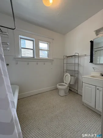 a bathroom with a toilet sink and mirror