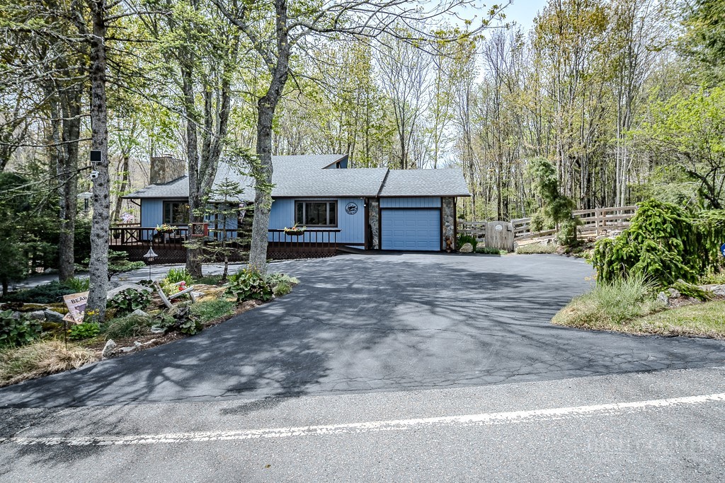 103-105 Upper Grouse Ridge Road Beech Mountain, NC 28604 - Photo 12 of 48 a front view of a house with garden