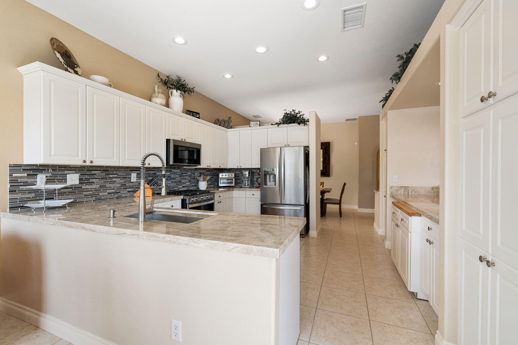 215 Strada Nova Palm Desert, CA 92260 - Photo 19 of 44 a kitchen with stainless steel appliances granite countertop a refrigerator and a stove