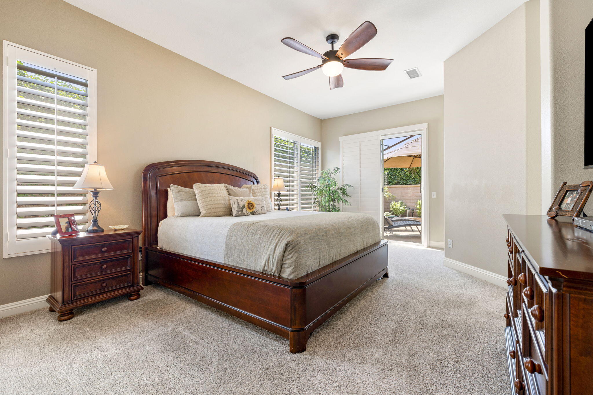 215 Strada Nova Palm Desert, CA 92260 - Photo 21 of 44 a bedroom with a bed dresser and a flat tv screen