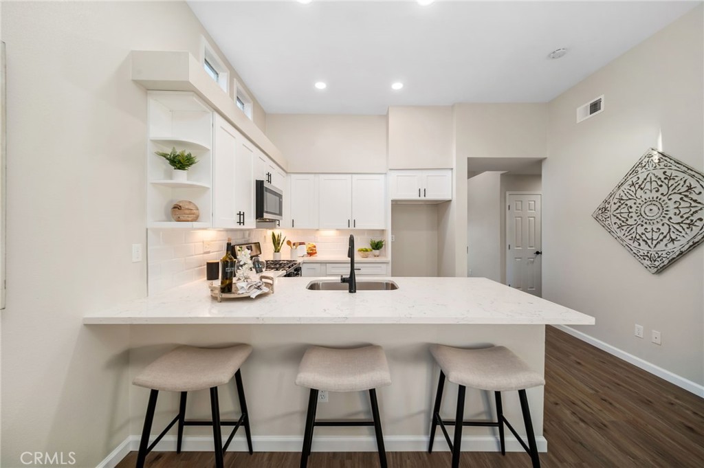 31577 Via Santa Ines Temecula, CA 92592 - Photo 17 of 49 a kitchen with kitchen island a dining table and chairs