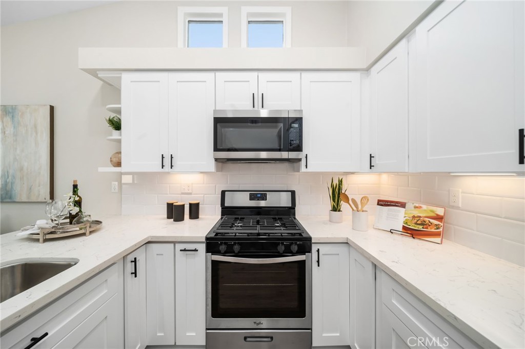 31577 Via Santa Ines Temecula, CA 92592 - Photo 21 of 49 a kitchen with stainless steel appliances a stove a sink and a microwave