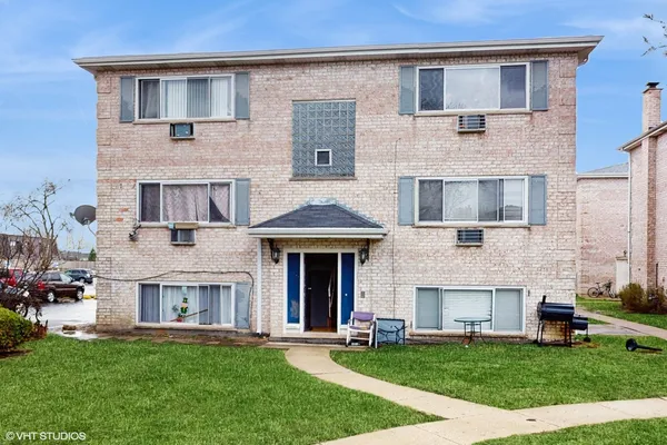 a front view of a brick building with a yard