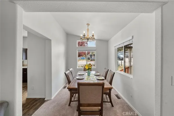 a view of a dining room with furniture and chandelier