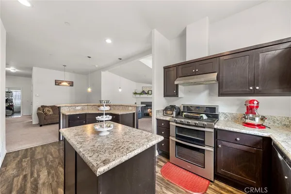 a kitchen with stainless steel appliances granite countertop sink stove top oven and microwave