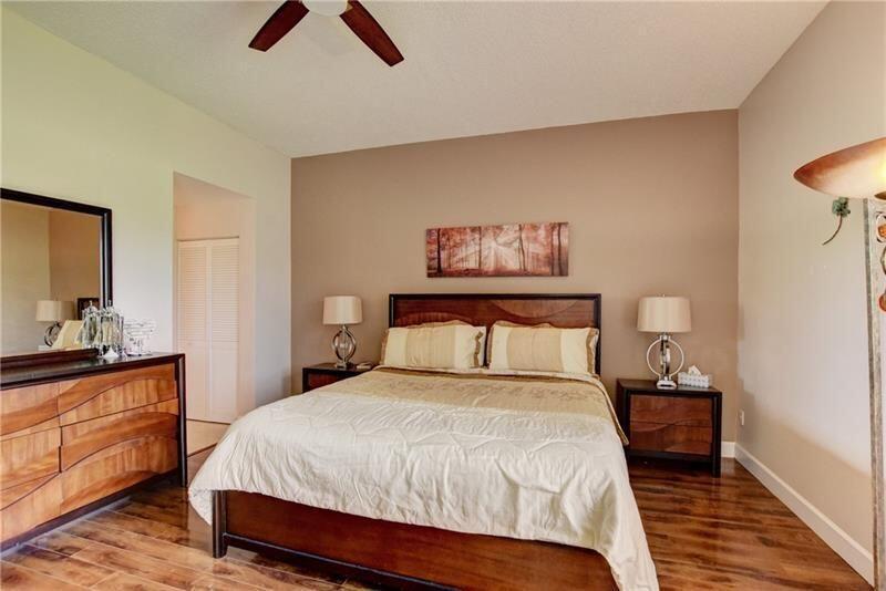 7448 La Paz Boulevard, Unit 104 Boca Raton, FL 33433 - Photo 11 of 16 a bedroom with a bed and painting on the wall