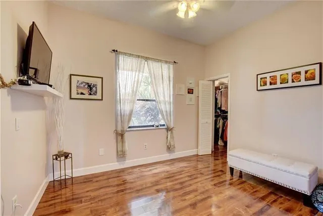 a view of an empty room with a window and a flat screen tv