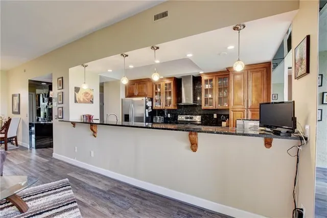 a kitchen with stainless steel appliances a refrigerator sink and microwave