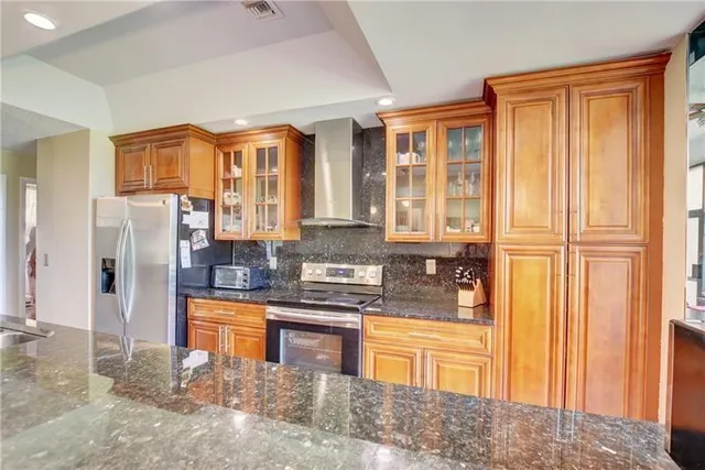a kitchen with stainless steel appliances granite countertop a refrigerator and stove