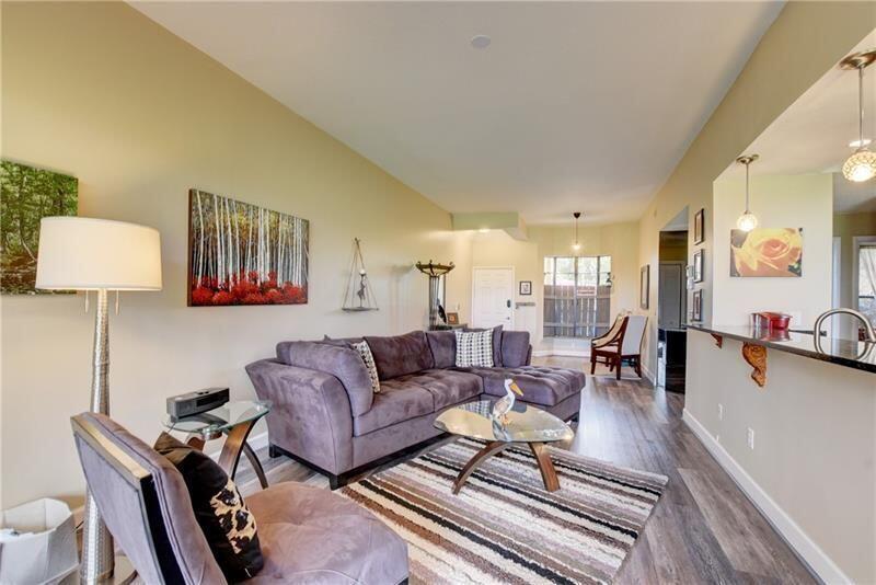 7448 La Paz Boulevard, Unit 104 Boca Raton, FL 33433 - Photo 10 of 16 a living room with furniture and a lamp