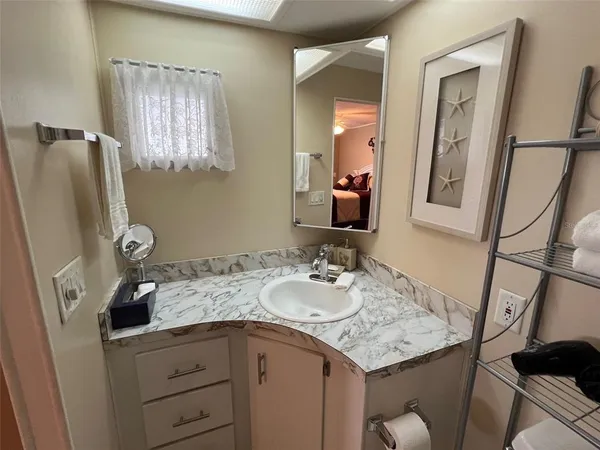 a bathroom with a granite countertop sink vanity and mirror