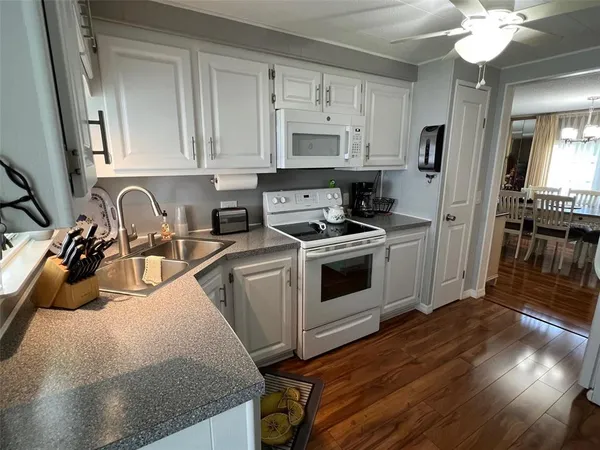 a kitchen with stainless steel appliances granite countertop a sink a stove and cabinets