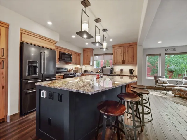 a kitchen with stainless steel appliances granite countertop a sink a stove and a refrigerator