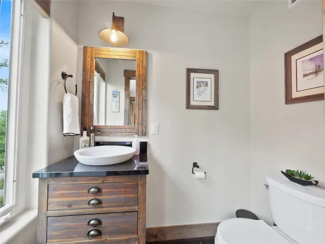a bathroom with a toilet a sink and mirror