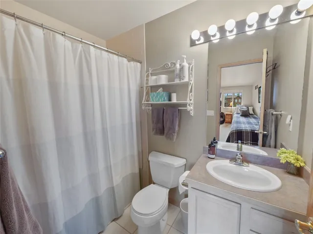 a bathroom with a toilet a sink a light fixture and a mirror