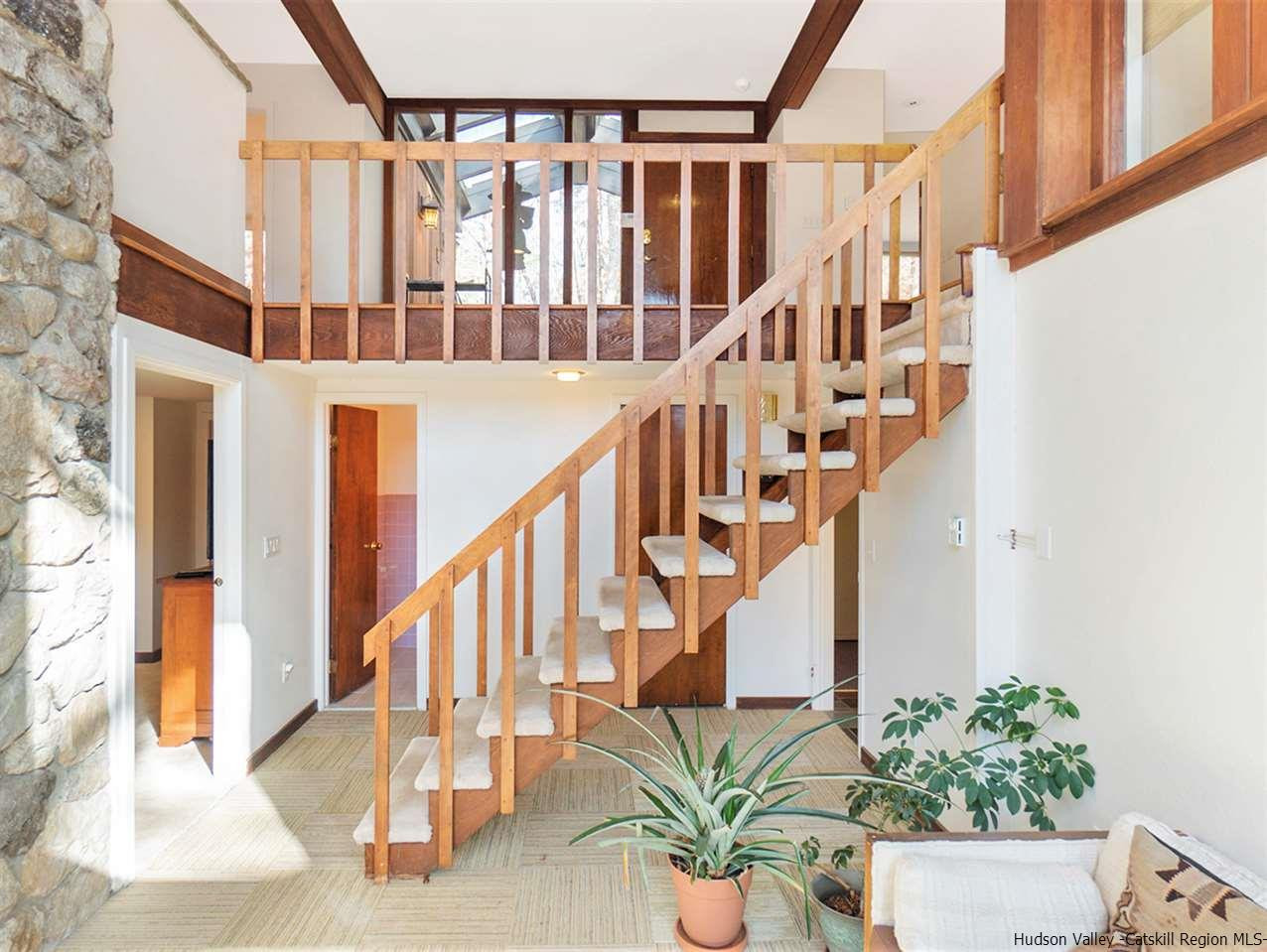 118 Sparkling Ridge Road New Paltz, NY 12561 - Photo 23 of 35 a view of staircase with lots of frames on wall and a potted plant
