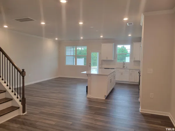 a living room with wooden floors and white walls