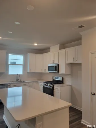 a kitchen with kitchen island a stove a sink and a refrigerator