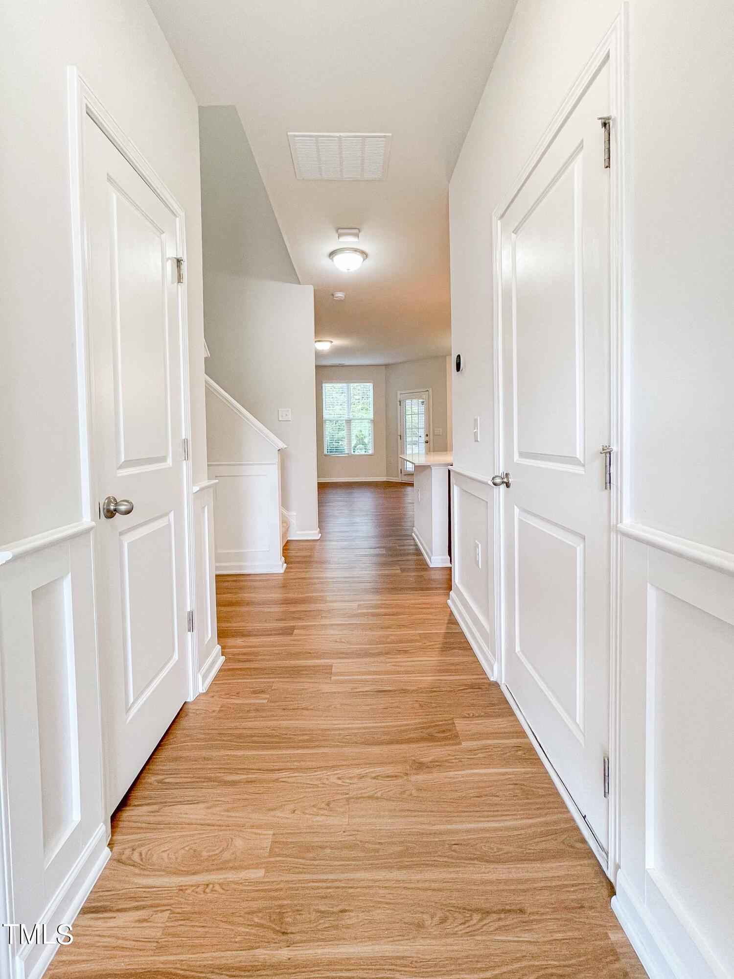 6027 Beale Loop Raleigh, NC 27616 - Photo 4 of 21 a view of a hallway with wooden floor and staircase