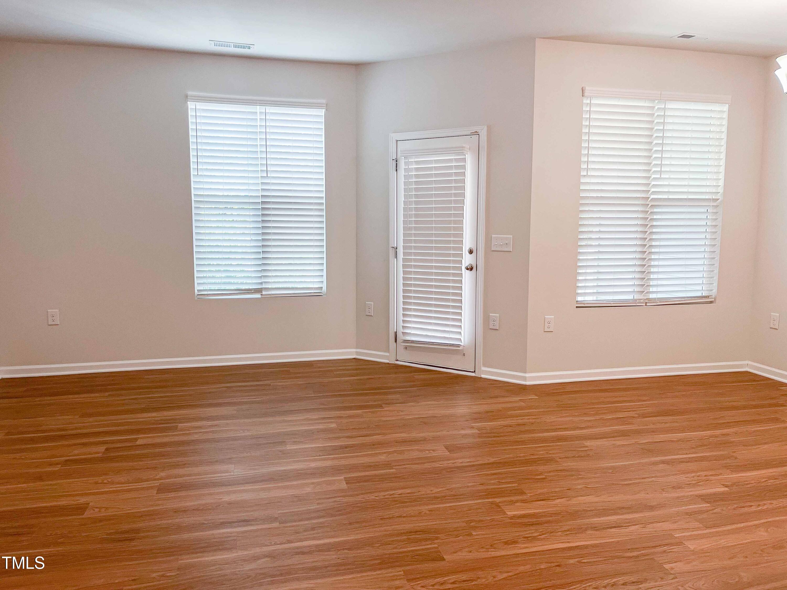 6027 Beale Loop Raleigh, NC 27616 - Photo 7 of 21 a view of an empty room with wooden floor and a window