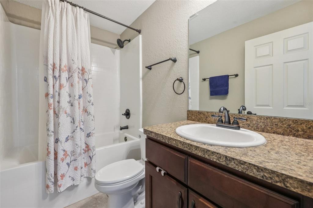 176 Juniper Loop Circle Ocala, FL 34480 - Photo 14 of 21 a bathroom with a granite countertop sink toilet mirror and shower