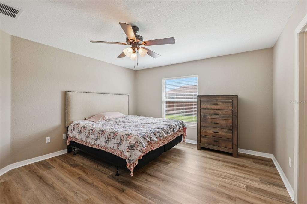 176 Juniper Loop Circle Ocala, FL 34480 - Photo 9 of 21 a bedroom with a bed and a ceiling fan