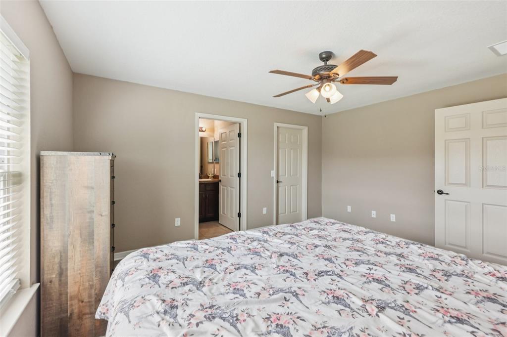 176 Juniper Loop Circle Ocala, FL 34480 - Photo 10 of 21 a bedroom with a bed and a chandelier