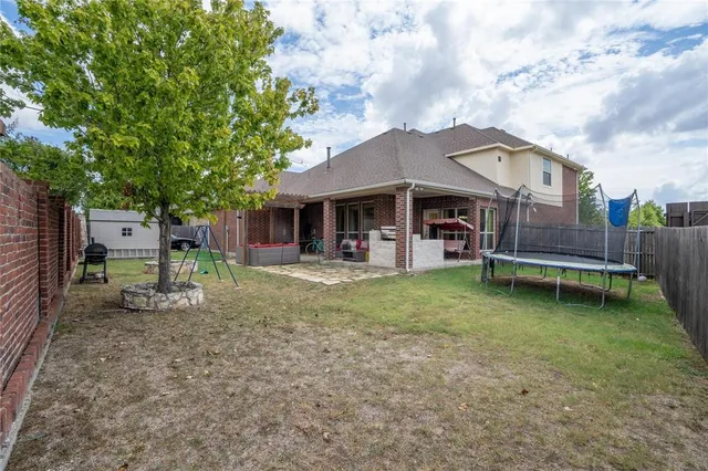 a backyard of a house with barbeque oven table and chairs