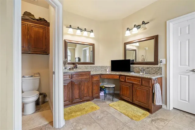 a spacious bathroom with a granite countertop sink toilet and shower