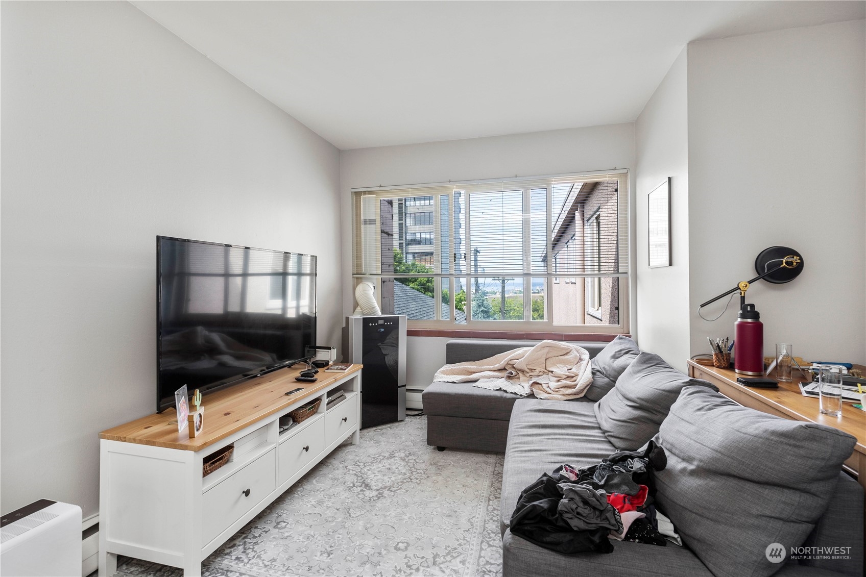 601 East Roy Street Seattle, WA 98102 - Photo 20 of 26 a living room with furniture a flat screen tv and a floor to ceiling window