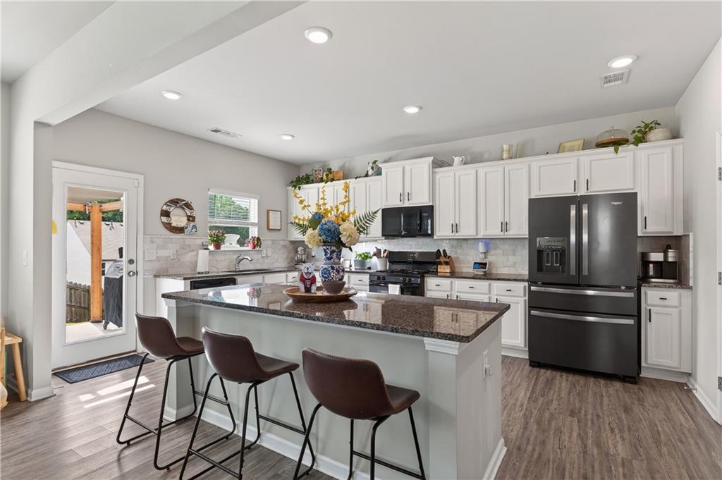 266 Shoals Bridge Road Acworth, GA 30102 - Photo 12 of 43 a kitchen with refrigerator a stove a sink and chairs