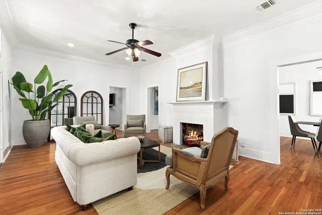 a living room with furniture a fireplace and wooden floor