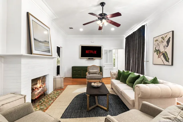 a living room with furniture a fireplace and a flat screen tv