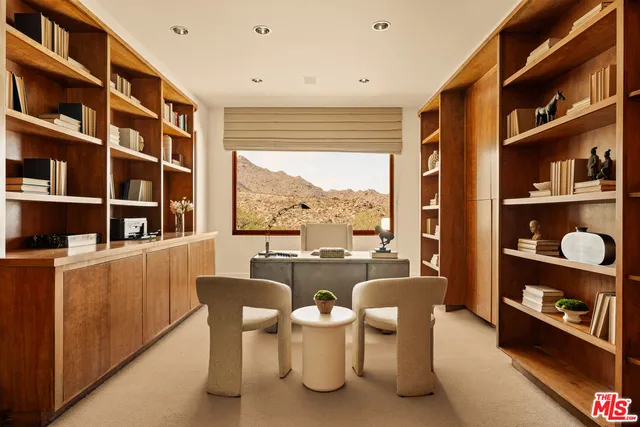 a dining room with furniture and a large window