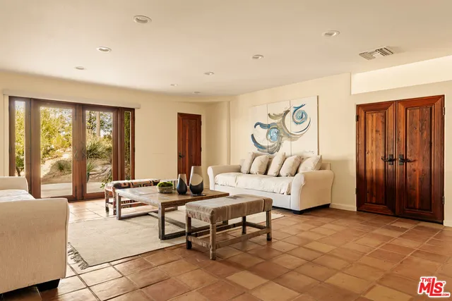 a living room with furniture and large windows