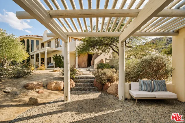 a view of a patio with couches table and chairs and potted plants