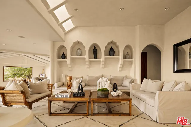 a living room with patio furniture and fireplace