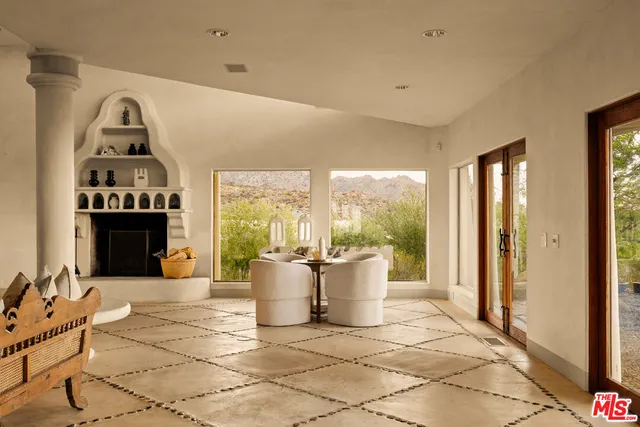 a living room with fireplace furniture and a large window