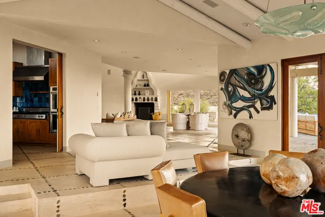 a living room with furniture a rug and white walls