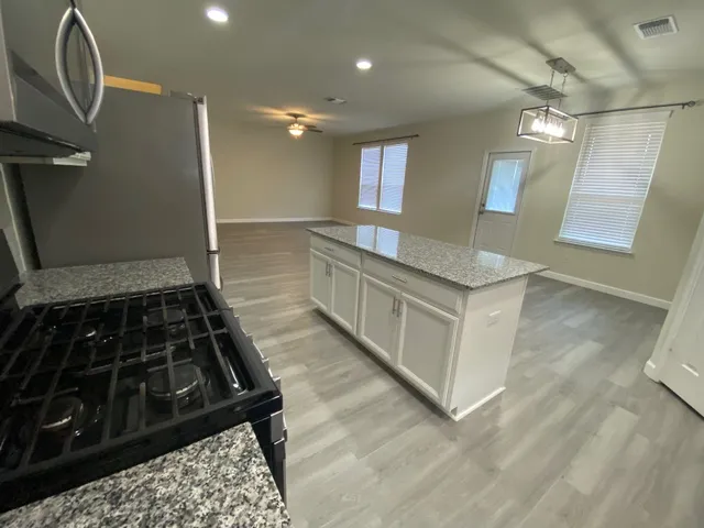 a kitchen with granite countertop a stove and a sink