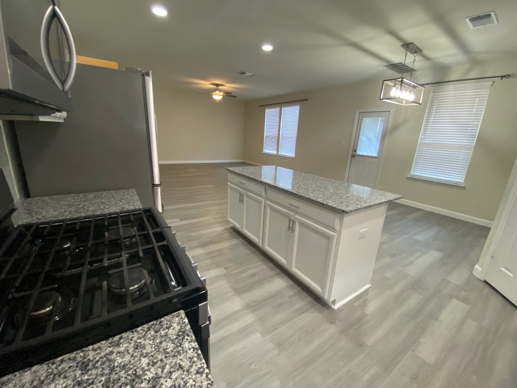 97 Quarryman Drive Hutto, TX 78634 - Photo 13 of 37 a kitchen with granite countertop a stove and a sink