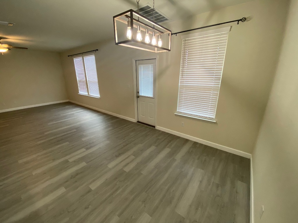 97 Quarryman Drive Hutto, TX 78634 - Photo 16 of 37 an empty room with wooden floor and windows