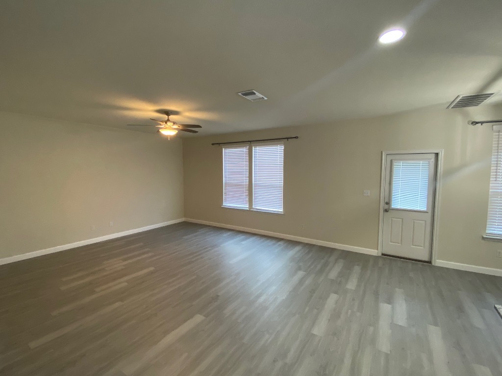 97 Quarryman Drive Hutto, TX 78634 - Photo 3 of 37 a view of an empty room with wooden floor and a window