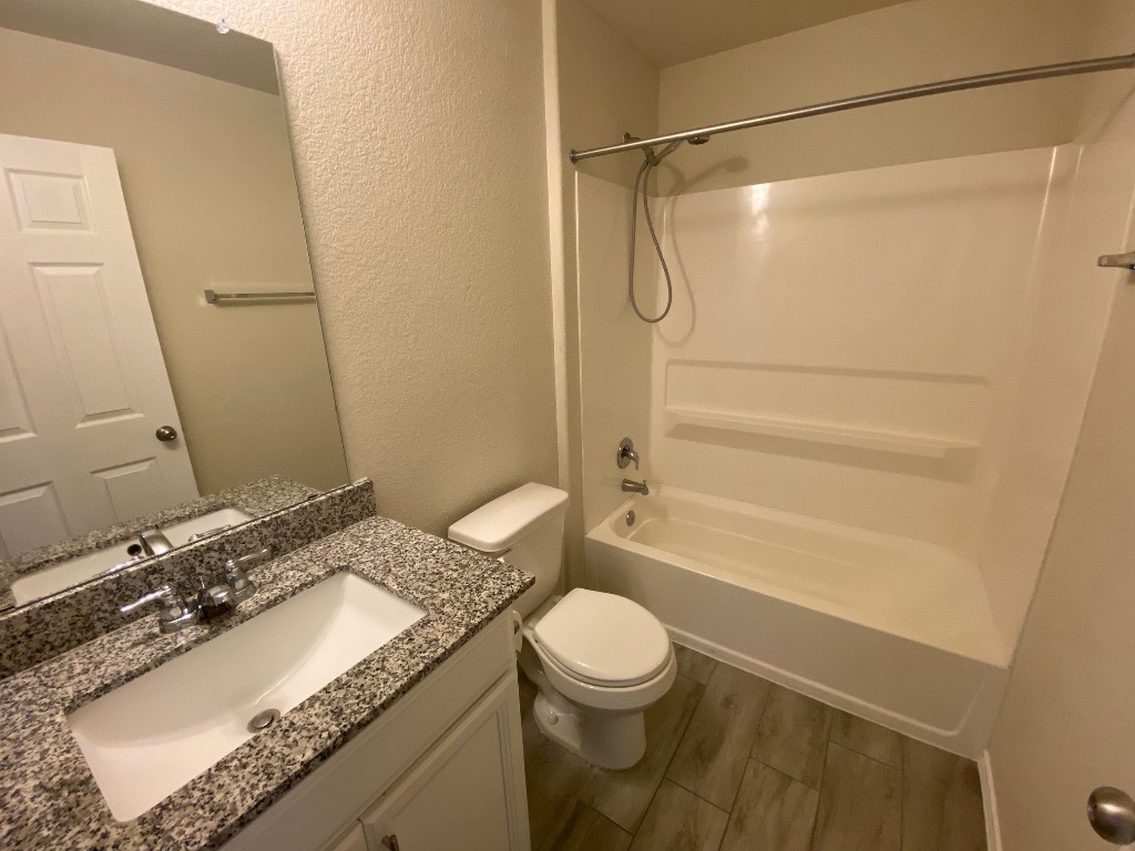 97 Quarryman Drive Hutto, TX 78634 - Photo 31 of 37 a bathroom with a granite countertop sink toilet and shower