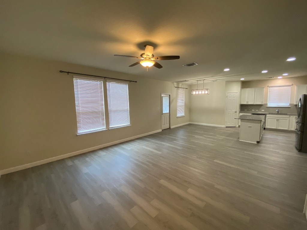 97 Quarryman Drive Hutto, TX 78634 - Photo 7 of 37 wooden floor in an empty room with a window