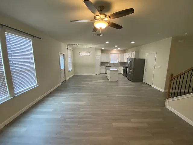 a view of a livingroom with a chair and a ceiling fan