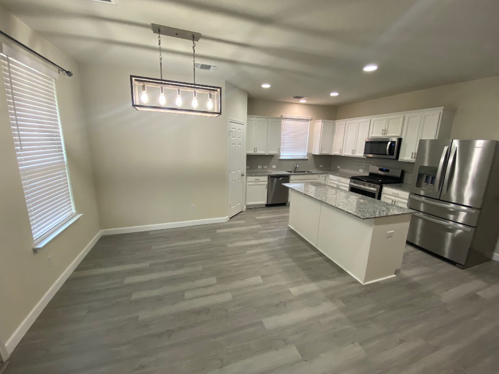97 Quarryman Drive Hutto, TX 78634 - Photo 9 of 37 a kitchen with stainless steel appliances granite countertop a stove a refrigerator and a sink